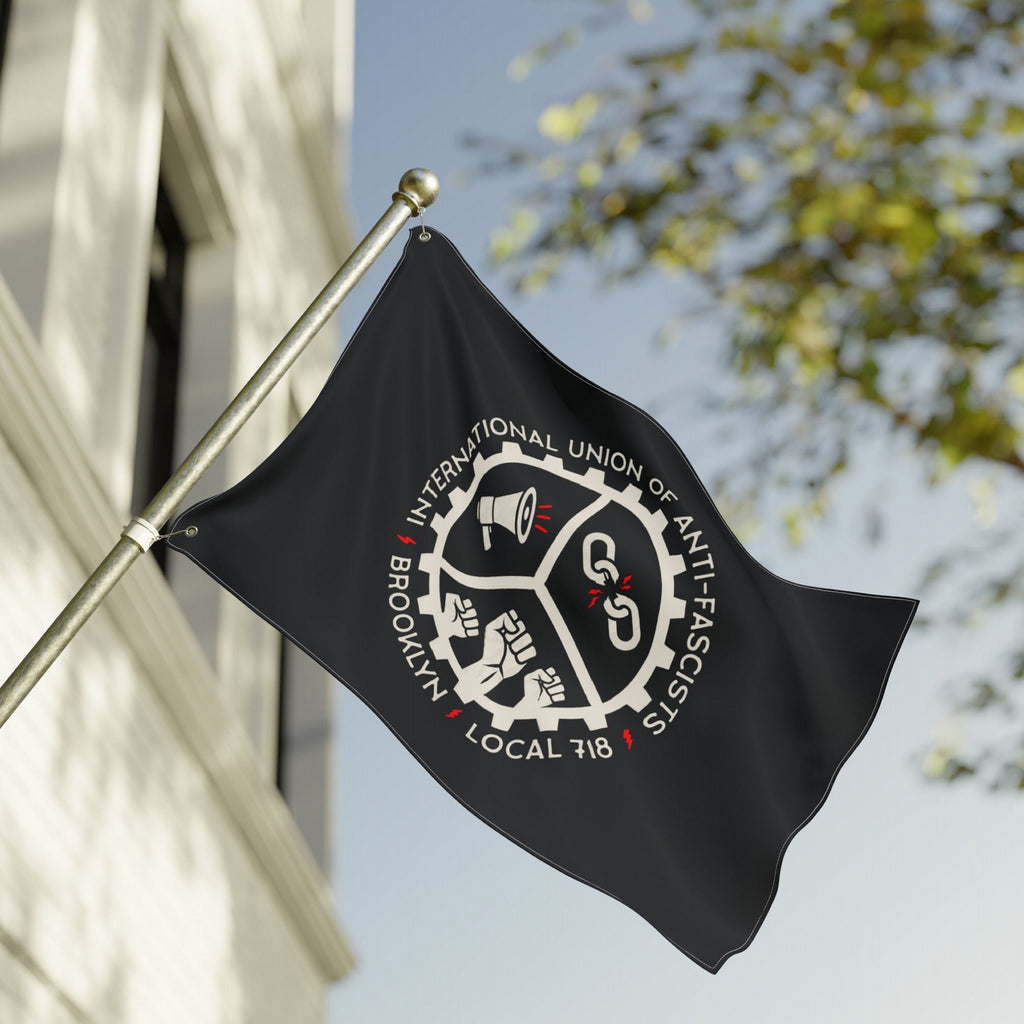 Brooklyn Anti-Fascist Union Flag features a gear-shaped seal with a megaphone, broken chain, and clenched fists, symbolizing resistance. It’s ideal for protests, marches, and community spaces.