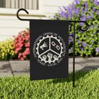 Texas Anti-Fascist Union Garden Flag on a metal stand features a gear-wheel emblem with icons and text, set against a garden backdrop, representing a bold anti-fascist statement.