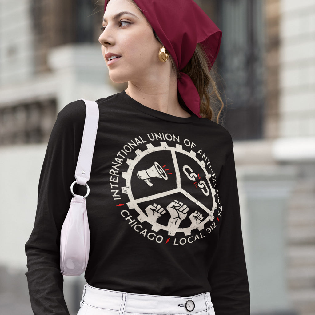Young woman outdoors in a Custom Anti-Fascist Union Long Sleeve T-shirt featuring a cog-style emblem with megaphone, broken chains, and fists, symbolizing protest energy and customizable for personal activism.