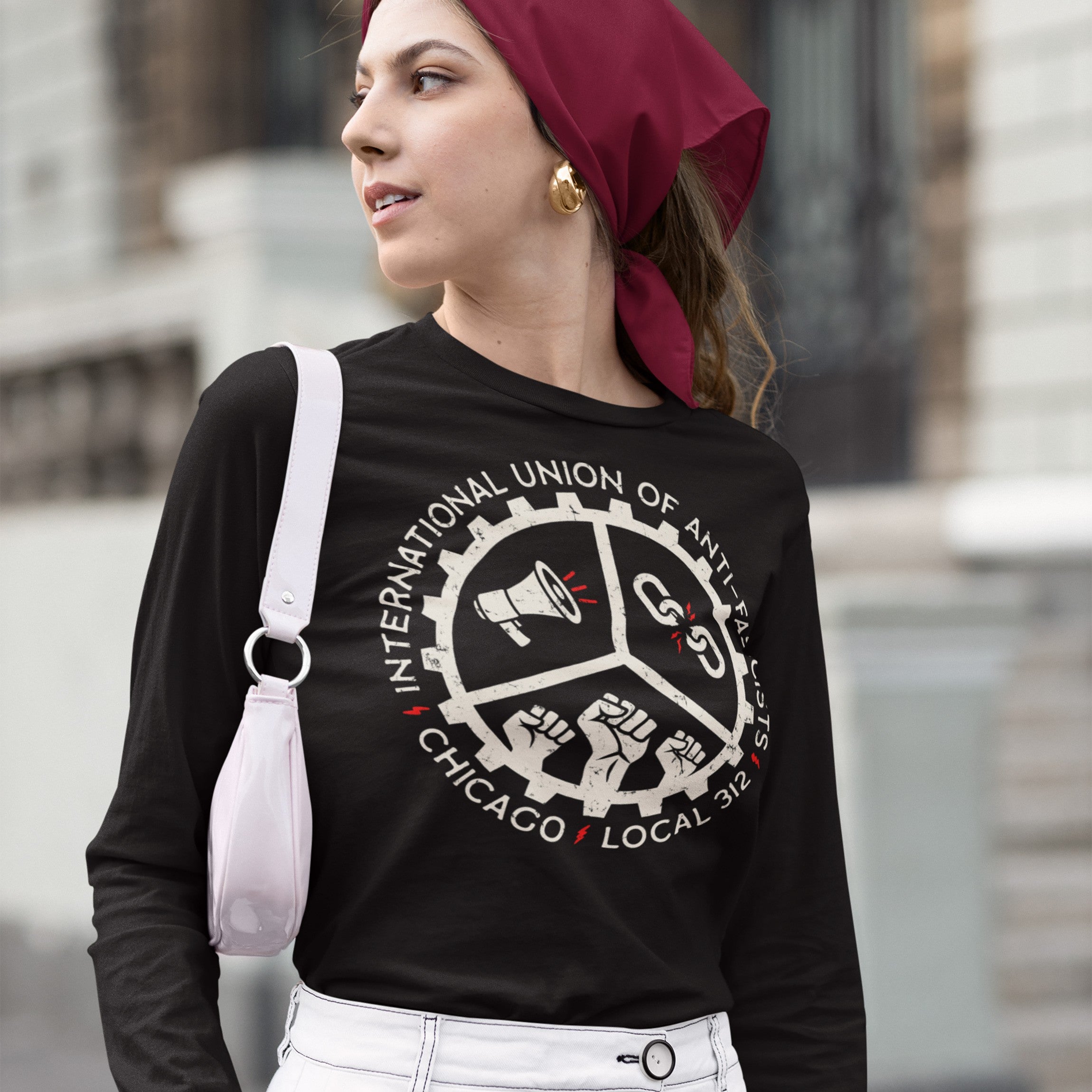 Young woman outdoors in a Custom Anti-Fascist Union Long Sleeve T-shirt featuring a cog-style emblem with megaphone, broken chains, and fists, symbolizing protest energy and customizable for personal activism.
