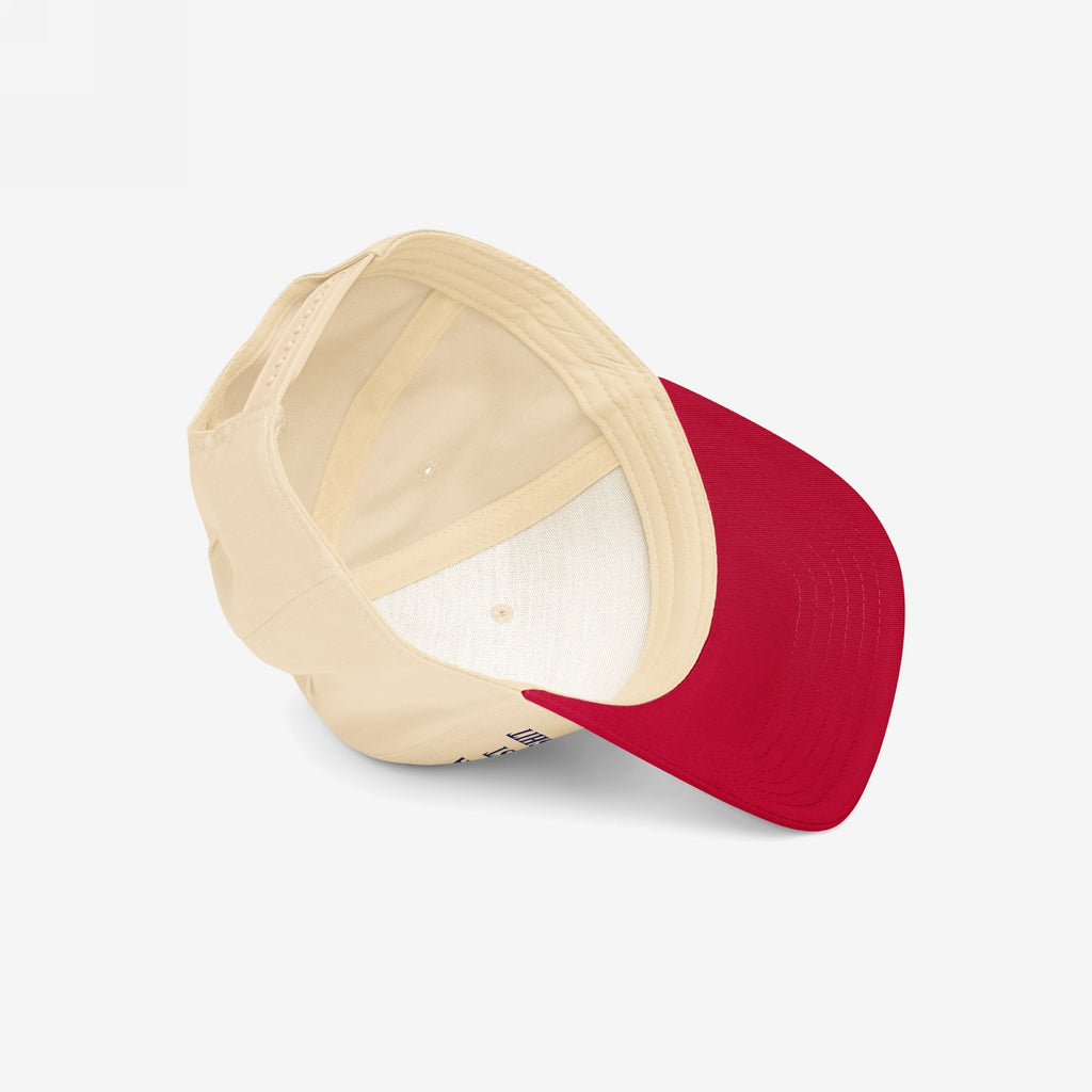 Anti-Racist Hat with a light beige crown and bright red bill, viewed from above. Features interior stitching and an adjustable back strap, embodying a bold stance against racism.