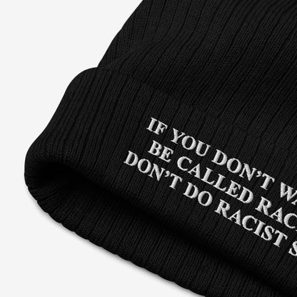 Black rib-knit beanie titled Anti-Racist Hat, featuring white embroidered text on the cuff: “IF YOU DON’T WANT TO BE CALLED RACIST, DON’T DO RACIST S…” advocating against racism with a bold message.