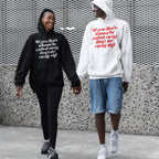 Two people walk hand-in-hand wearing the Anti-Racist Shirt, a hoodie with the slogan, “If you don’t wanna be called racist, don’t do racist shit,” embodying a bold stand against racism.