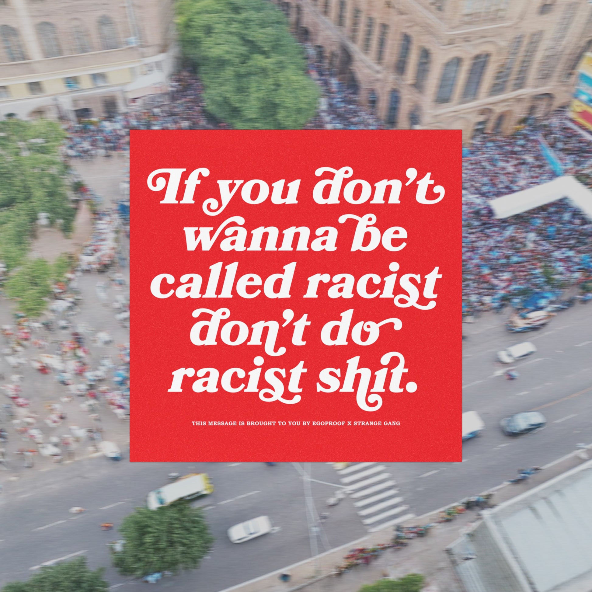Anti-Racist Sticker & Magnet with bold message against racism, featuring white text on a red square over blurred city backdrop. Collaboration with Egoproof, designed for visible advocacy against injustice.