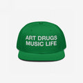 Green snapback hat with white embroidered “ART DRUGS MUSIC LIFE” text, embodying creative rebellion and expression. Perfect for art, music, and life enthusiasts seeking bold, unapologetic style.