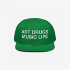Green snapback hat with white embroidered “ART DRUGS MUSIC LIFE” text, embodying creative rebellion and expression. Perfect for art, music, and life enthusiasts seeking bold, unapologetic style.