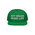 Green snapback hat with white embroidered “ART DRUGS MUSIC LIFE” text, embodying creative rebellion and expression. Perfe