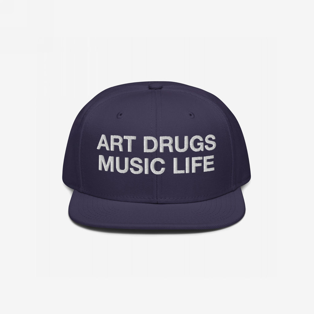 The Art Drugs Music Life Hat features bold white embroidery, declaring creativity and chaos with its mantra on a dark navy-blue snapback, embodying a rebellious spirit through art and music.