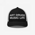 Art Drugs Music Life Hat showcases a black trucker cap with a bold white slogan on the front, embodying a spirit of creativity and expression for those embracing art, chaos, and sound.