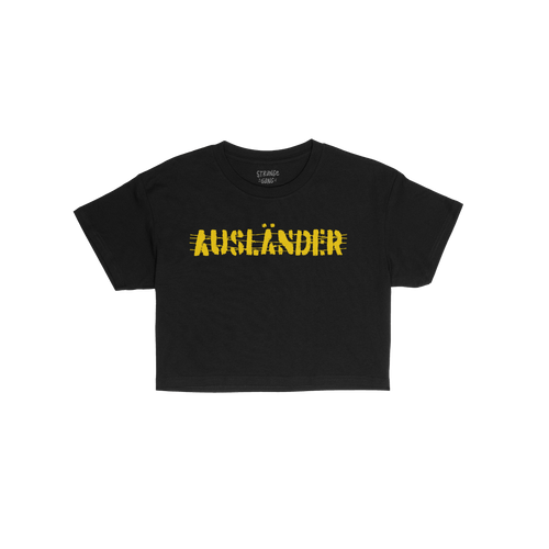 Ausländer Women's Baby Tee features AUSLÄNDER in bold, yellow hand-drawn–style font across the chest, embodying a stateme