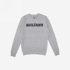 Light-gray long-sleeve crewneck sweatshirt with AUSLÄNDER in distressed black print across the chest, representing empowerment and resilience, part of the Ausländer Hoodie & Sweatshirt collection.