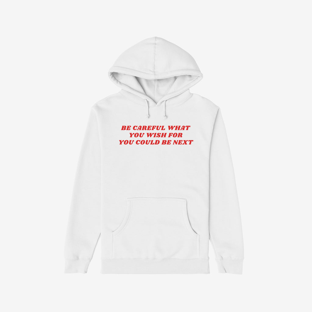 Plain white pullover hoodie featuring bold red text: Be Careful What You Wish For You Could Be Next. This Be Careful Shirt embodies protest and defiance against authoritarianism and extremism.