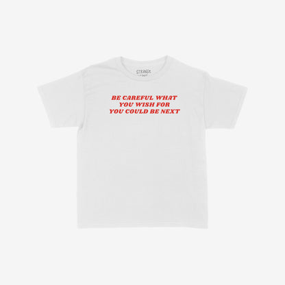 Be Careful T-shirt features bold red text stating, “BE CAREFUL WHAT YOU WISH FOR YOU COULD BE NEXT,” embodying a rebellious statement against authoritarianism, with a faint brand mark above the collar.