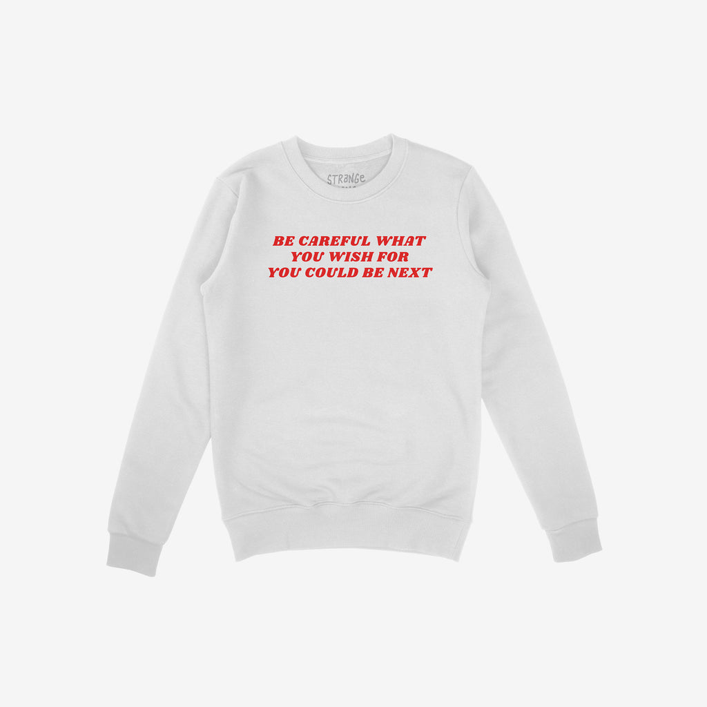 White crew-neck sweatshirt featuring bold red text: BE CAREFUL WHAT YOU WISH FOR YOU COULD BE NEXT. The Be Careful Shirt challenges authoritarianism, embodying a message of resistance and empowerment.