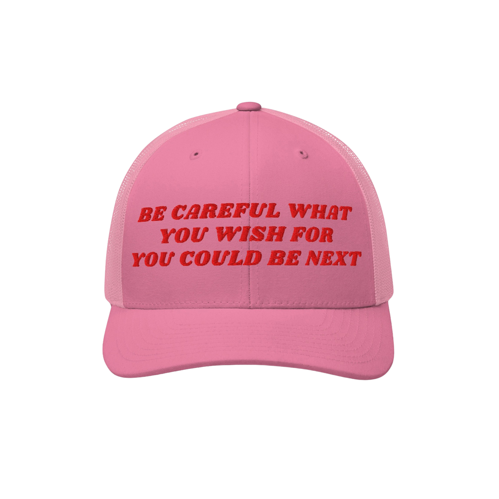 The Be Careful Hat features bold red embroidery on a pink trucker cap, delivering a sharp political message ideal for progres