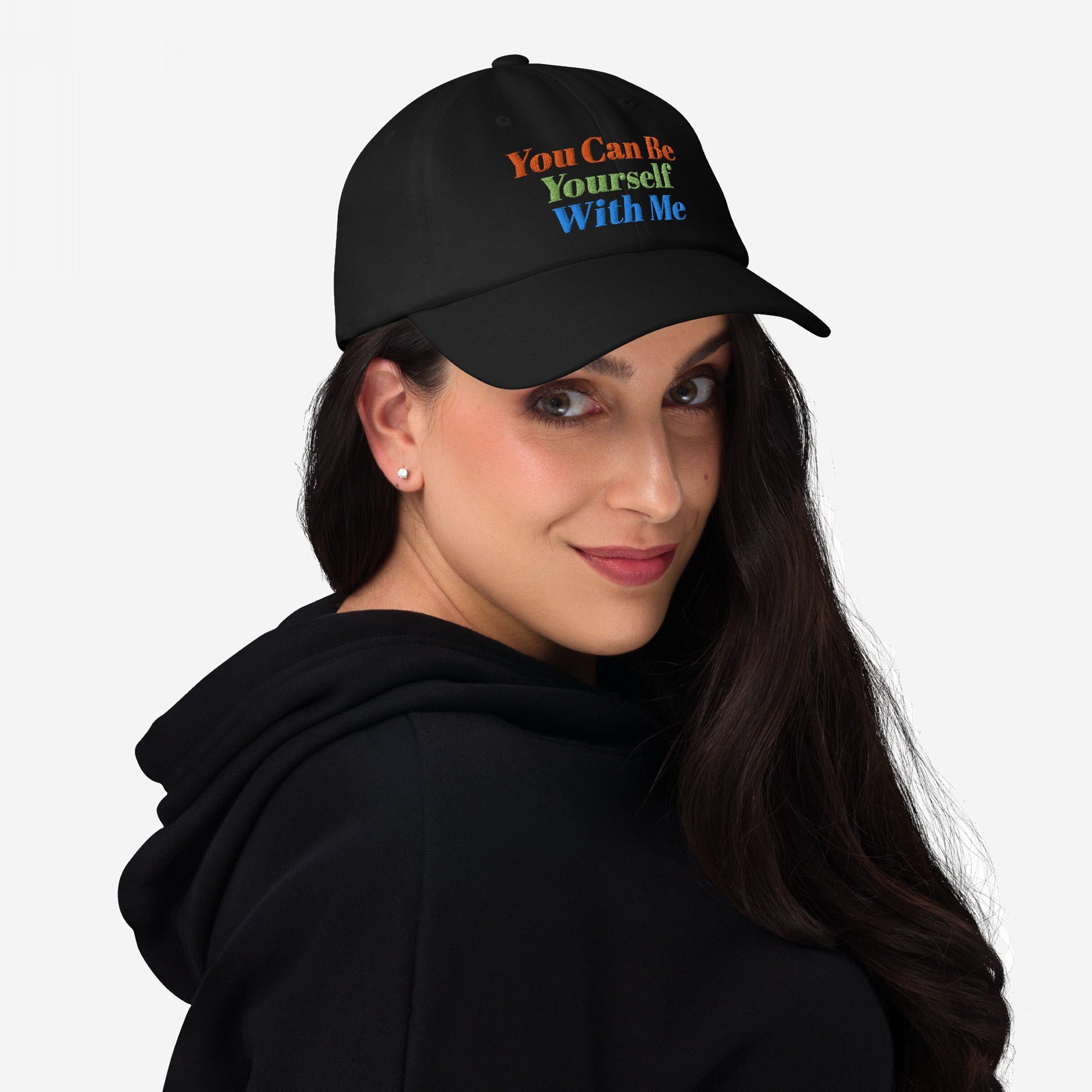 Woman wearing Be Yourself Hat with slogan “You Can Be Yourself With Me,” showcasing individuality and inclusivity. The black cap complements her casual look, aligning with the store's advocacy for equality and self-expression.