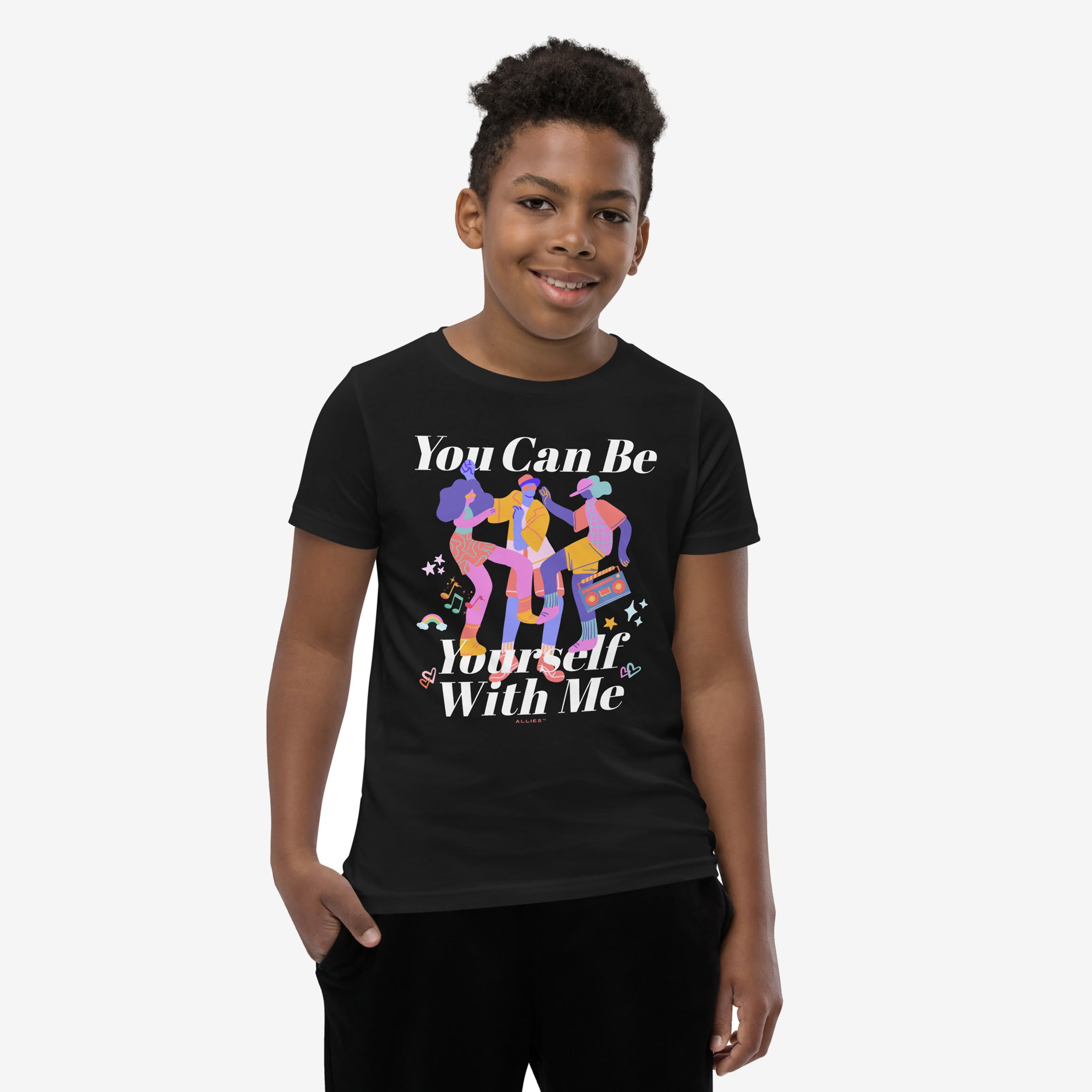 Teenage boy wearing the Be Yourself Shirt, featuring vibrant dancing figures, musical notes, rainbows, stars, and the slogan You Can Be Yourself With Me, celebrating individuality and inclusivity.