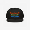 Black flat-brim snapback cap with vibrant embroidered text: You Can Be Yourself With Me. This Be Yourself Hat embodies individuality and inclusivity, reflecting a bold, supportive message.