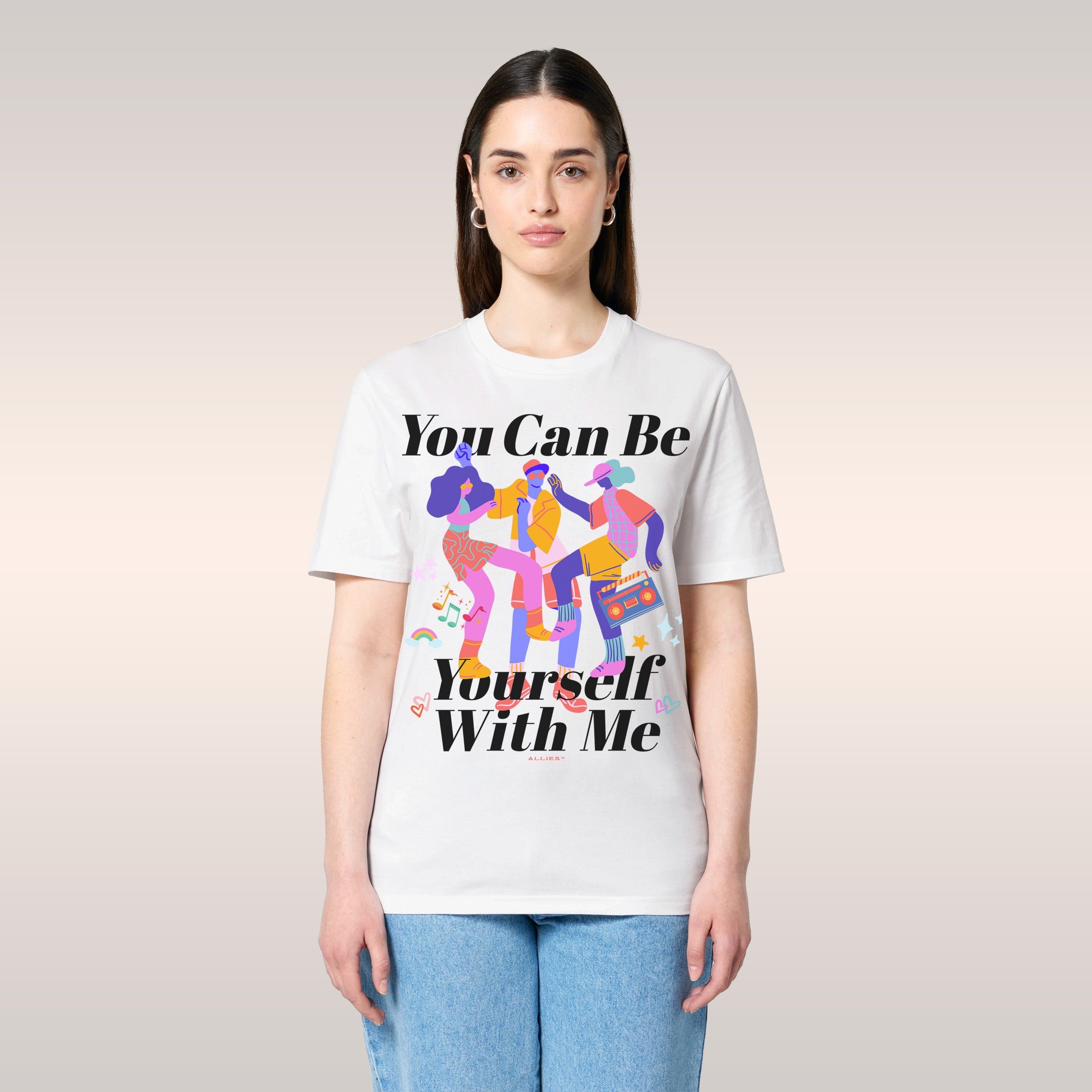 A young man makes a goofy face while wearing the Be Yourself Shirt, featuring playful dancers and text promoting self-express