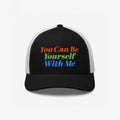 Black-front, white-mesh trucker cap with vibrant embroidery reading “You Can Be Yourself With Me,” embodying self-expression and inclusivity. Perfect for those embracing individuality and spreading positive messages.