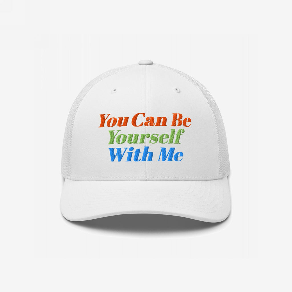 The Be Yourself Hat features a white trucker-style cap with bold embroidery that reads, You Can Be Yourself With Me, embodying inclusivity and self-expression with vibrant lettering.