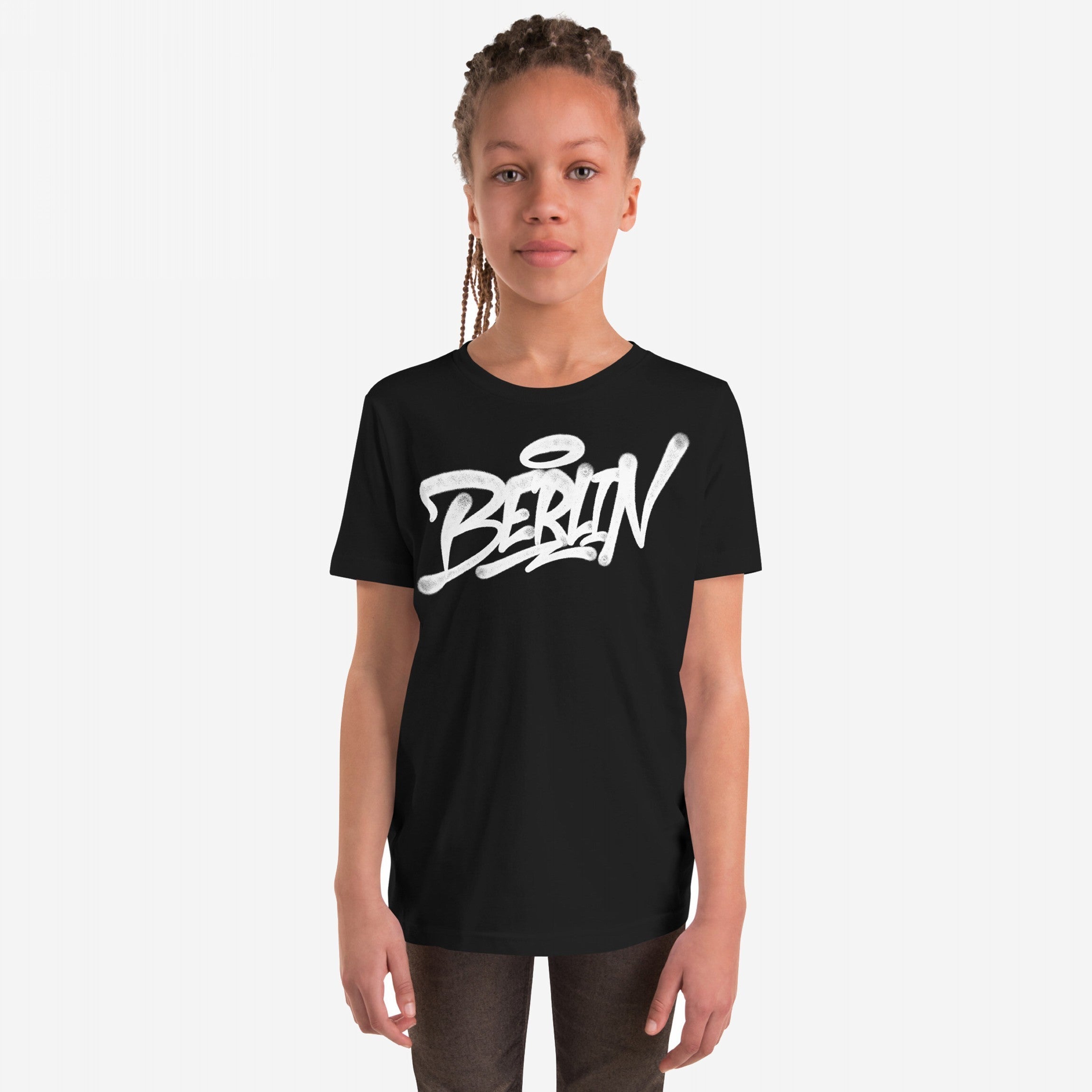Young person in a black Berlin Handstyle T-shirt, showcasing bold graffiti-inspired script, embodying urban street art vibes. Perfect for expressing individuality and city pride through casual, stylish wear.