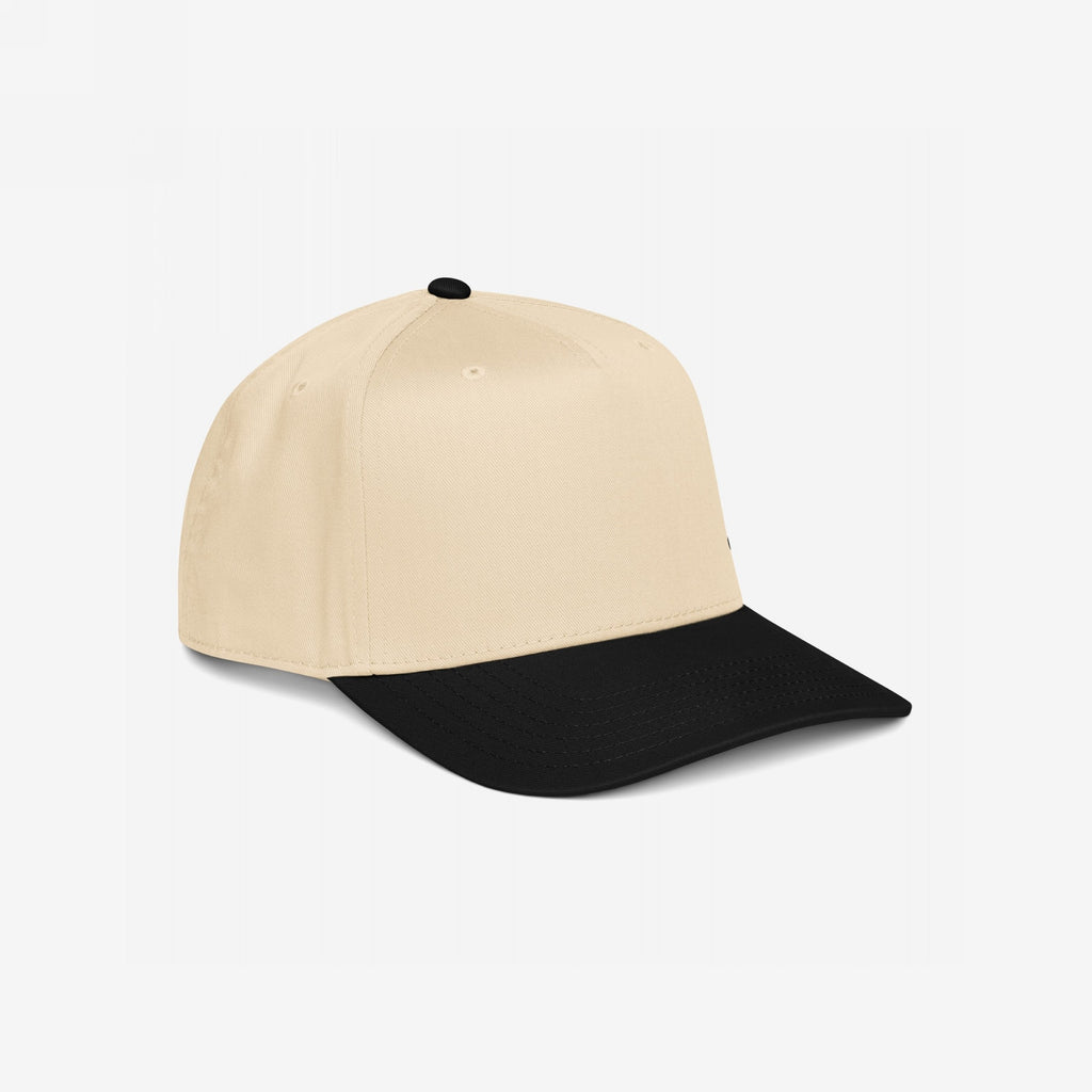 5-Panel Hat In Custom Colors featuring a light beige crown and black visor. This structured cap has stitched eyelets and an adjustable snapback, designed for activists seeking bold, personalized statements.