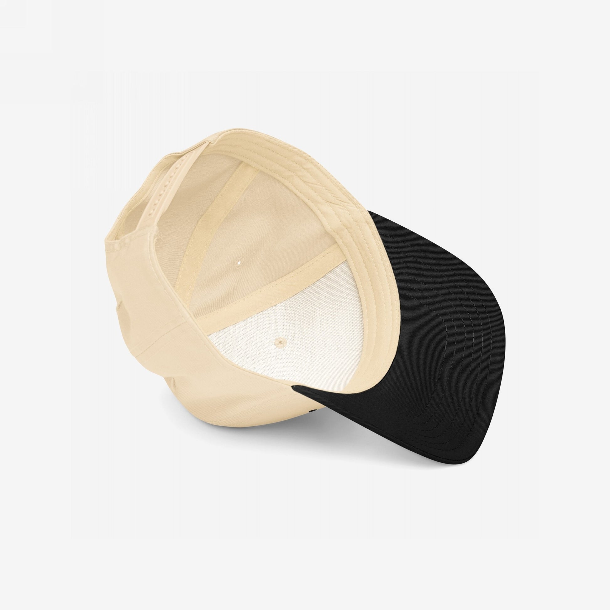 5-Panel Hat In Custom Colors, featuring a light beige crown and black brim, viewed inside-out, showcasing its structured design and adjustable snap closure, ideal for making bold, activist statements.