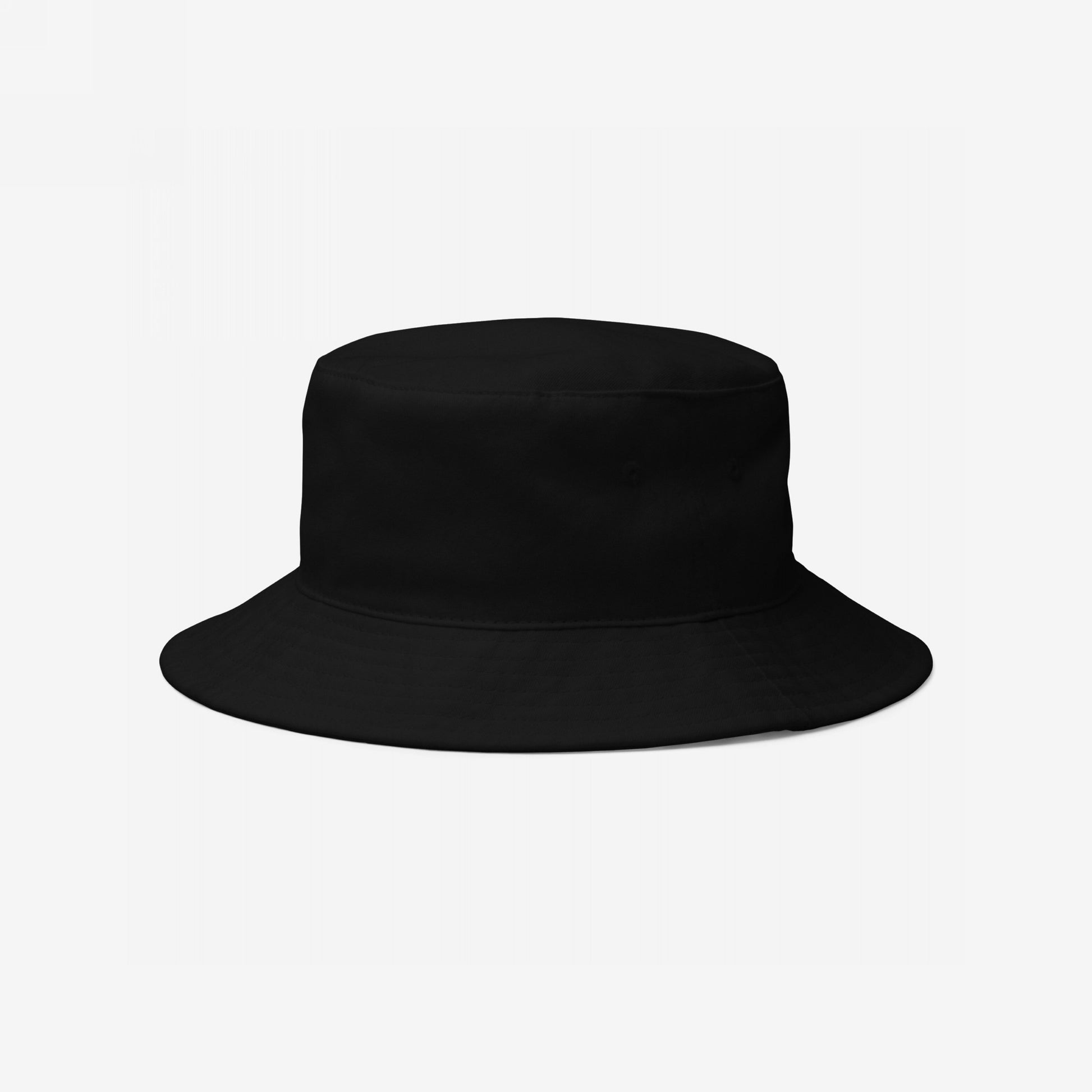 Bucket Hat In Custom Colors displayed against a neutral backdrop, showcasing a simple black design ready for custom embroidery. Features include a relaxed fit, sewn eyelets, and a protective brim.