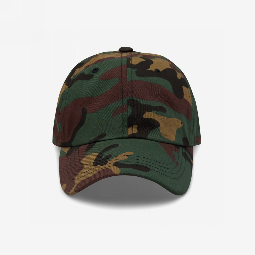 Dad Hat In Custom Colors features a woodland camouflage pattern with a curved brim and metal eyelets. Made from chino cotton twill, it includes an adjustable strap and customizable embroidered activist designs.