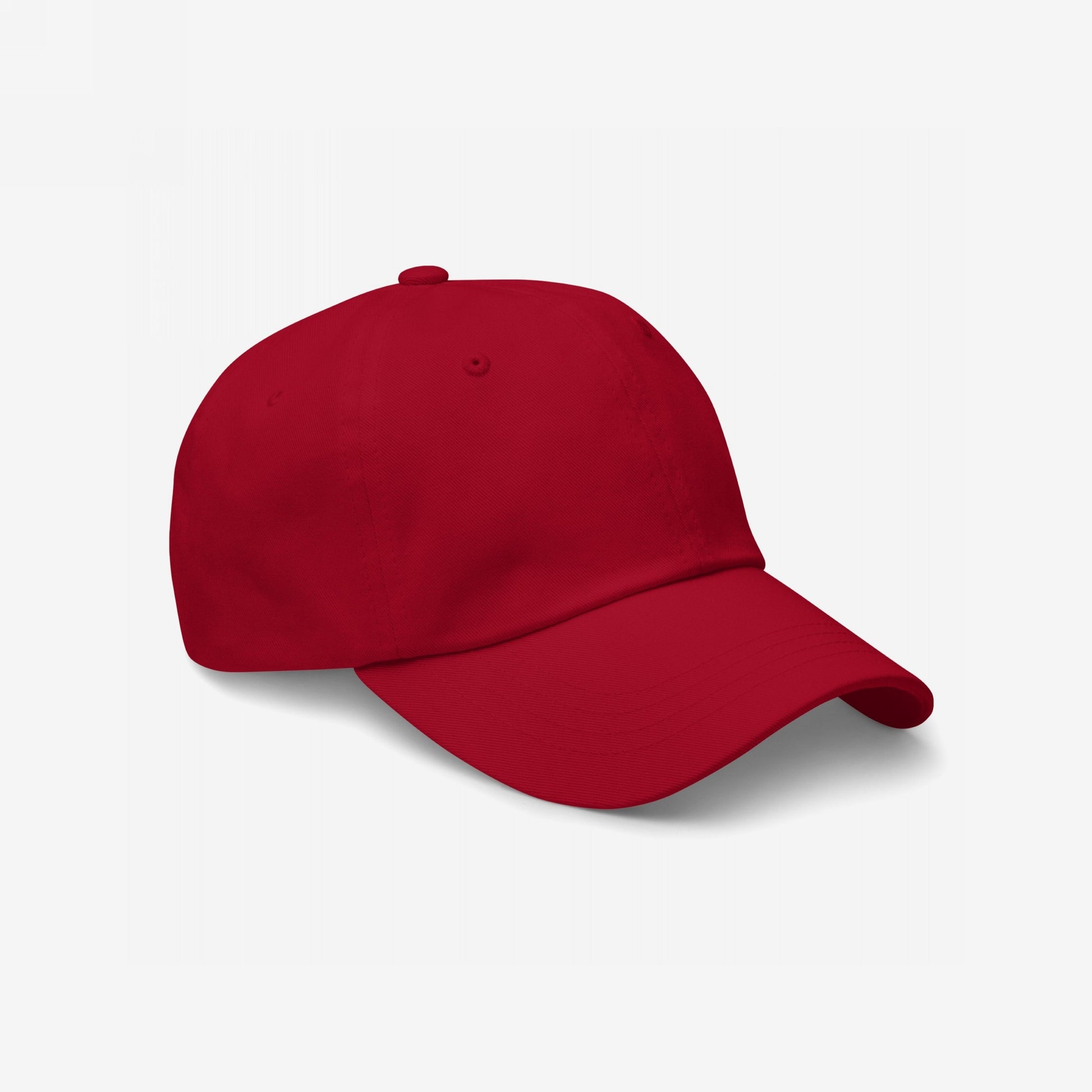Dad Hat In Custom Colors: A plain red, six-panel baseball cap against a white background, showcasing its low-profile, unstructured design. Perfect for displaying embroidered anti-fascist or activist messages.