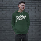 Young person in a forest-green Boston Handstyle Hoodie, featuring a white graffiti-style logo, stands against a brick wall, hands in kangaroo pocket, embodying the city's bold, authentic spirit.