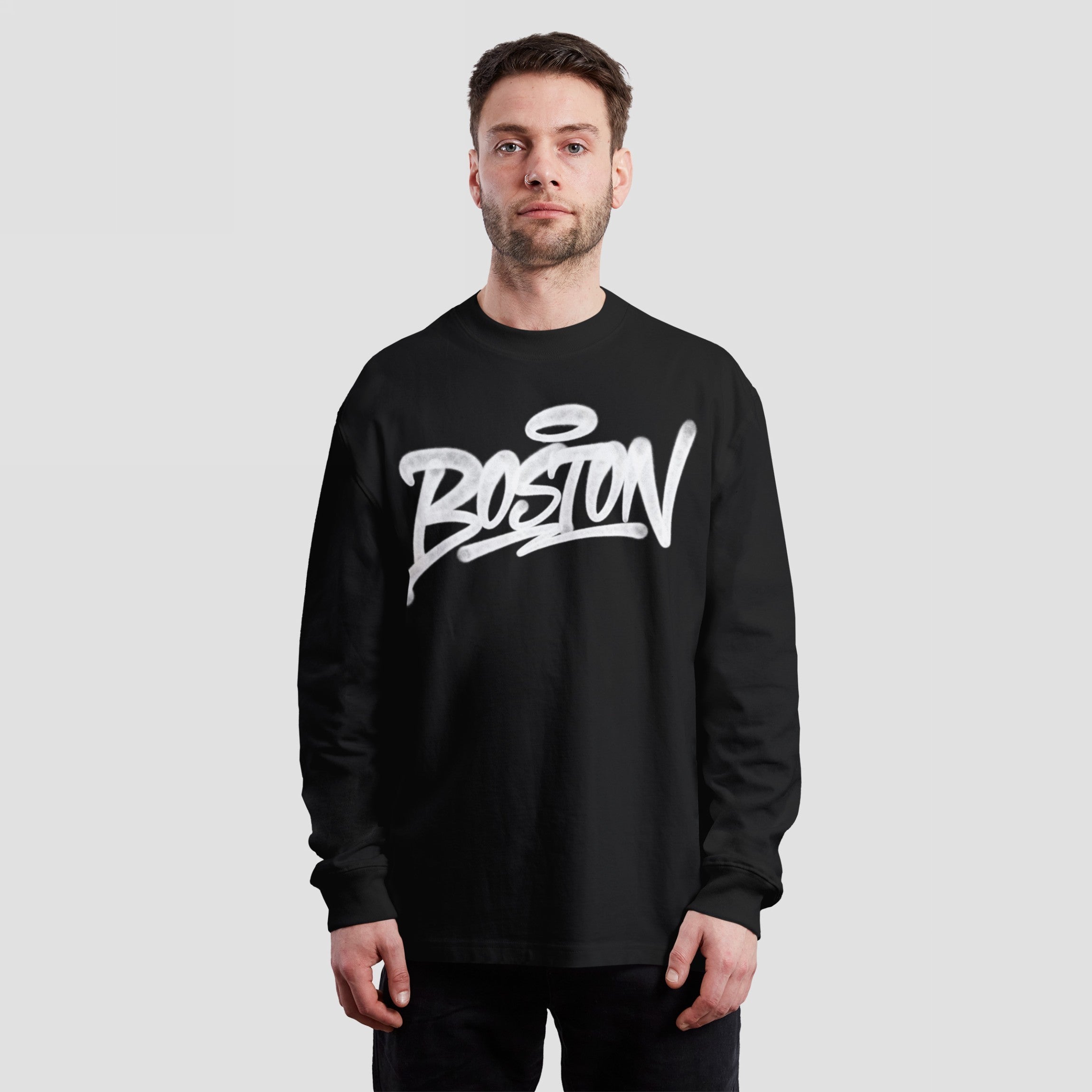 Male model wearing the Boston Handstyle T-shirt, a black long-sleeve featuring bold white graffiti-style BOSTON lettering across the chest, embodying the city's spirit and individuality.