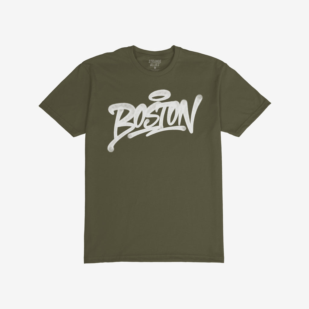 Olive-green Boston Handstyle T-shirt featuring a bold, white graffiti-style BOSTON wordmark with a halo accent, emphasizing urban flair and statement design.