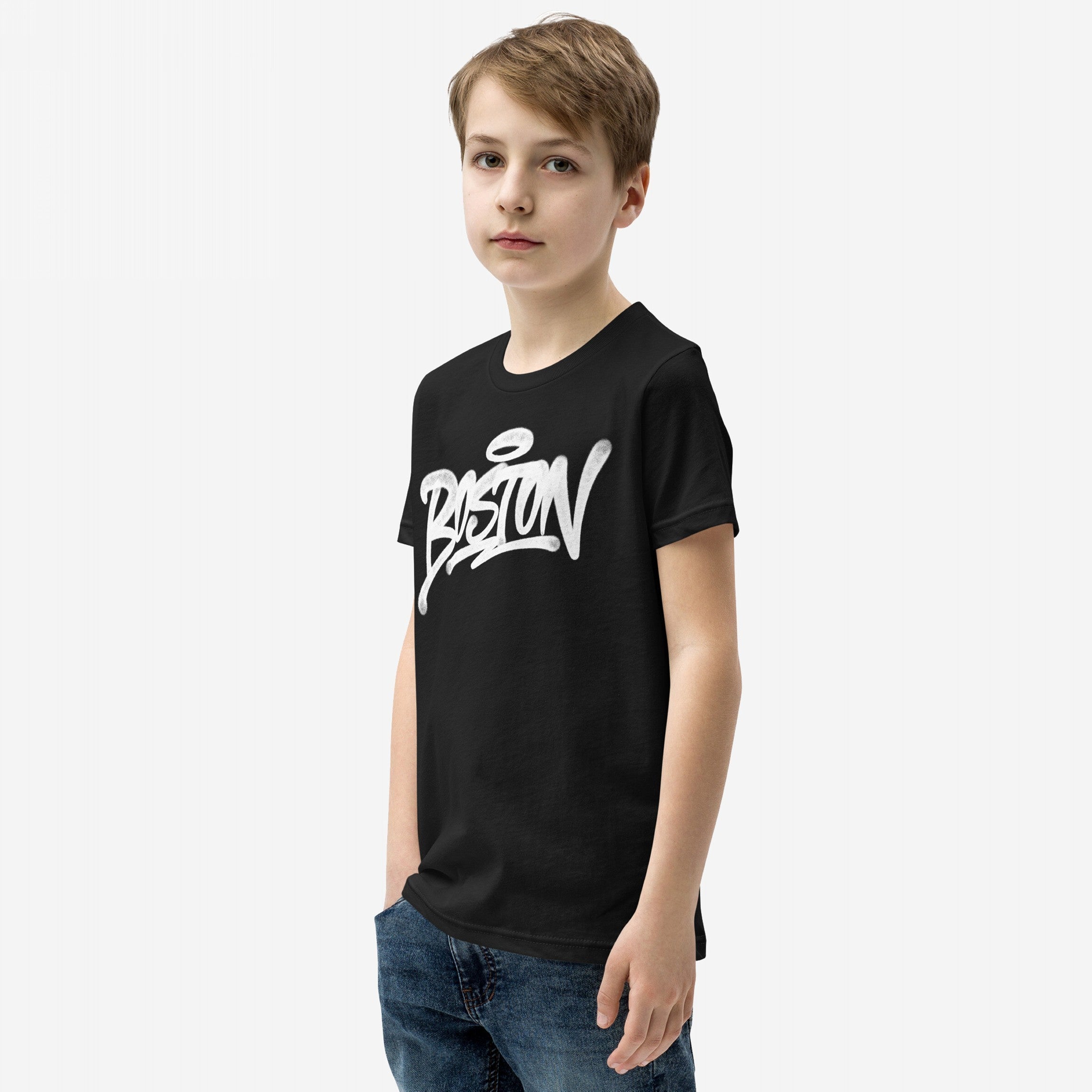 Young boy in a Boston Handstyle T-shirt featuring bold graffiti-style script, paired with blue jeans. This captures the urban, unapologetic spirit, embodying a strong statement against a plain white backdrop.