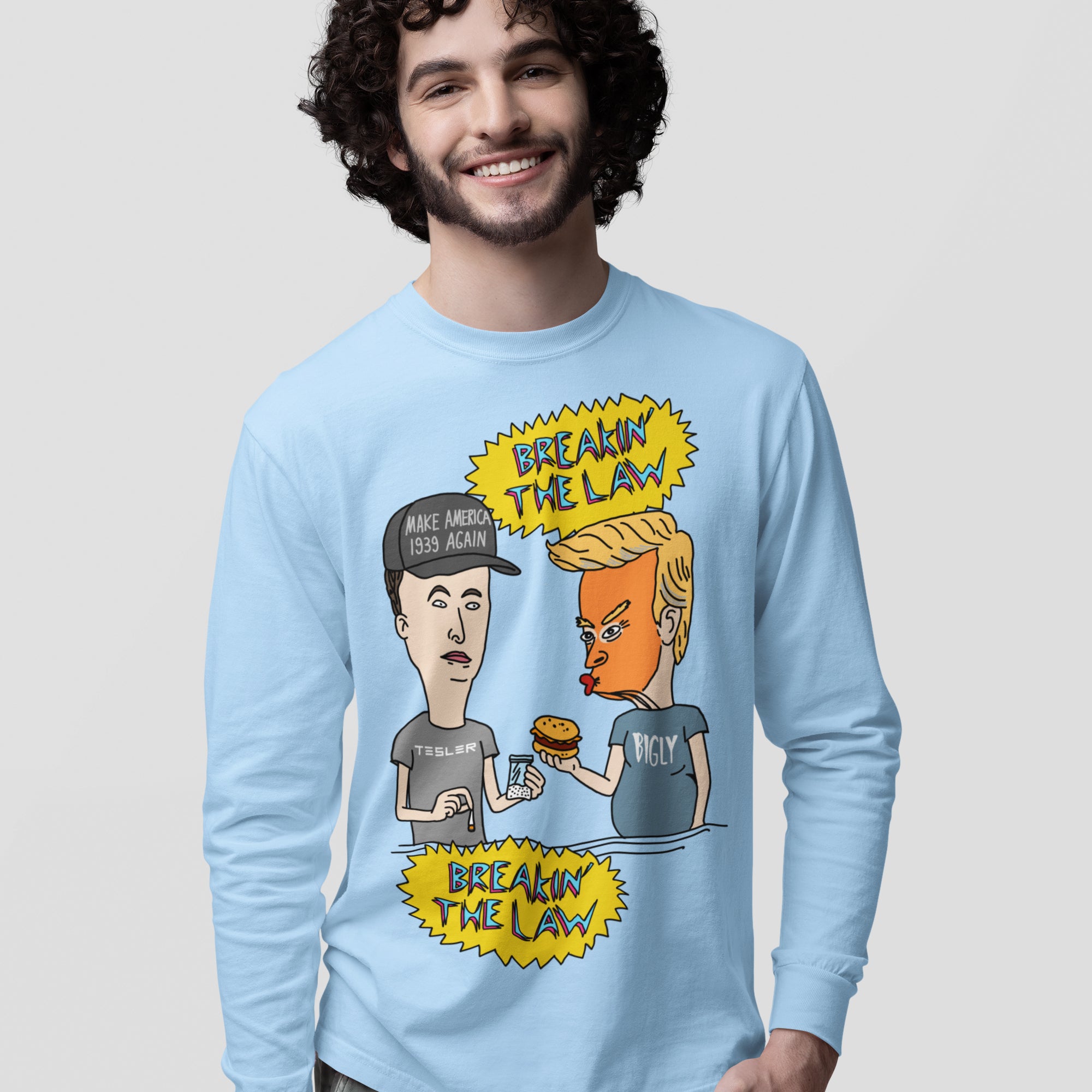 Young man wearing the Breakin' The Law Shirt, featuring a satirical cartoon of two figures—one with TESLER, the other BIGLY—exchanging items, with comic-style BREAKIN’ THE LAW text above and below.