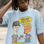 Breakin' The Law Shirt features a satirical cartoon of caricatured figures resembling Trump and Musk, humorously engaging with contraband and fast food, embodying anti-elitist and protest-centric themes.