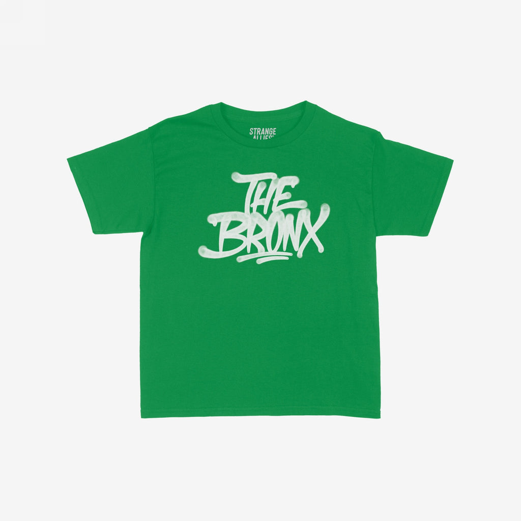 Bronx Handstyle Women's Baby Tee features “THE BRONX” in bold, graffiti-style script on a green short-sleeve shirt, embodying raw borough pride and NYC spirit. Label reads “STRANGE ALLIES.”