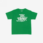 Bronx Handstyle Women's Baby Tee features “THE BRONX” in bold, graffiti-style script on a green short-sleeve shirt, embodying raw borough pride and NYC spirit. Label reads “STRANGE ALLIES.”