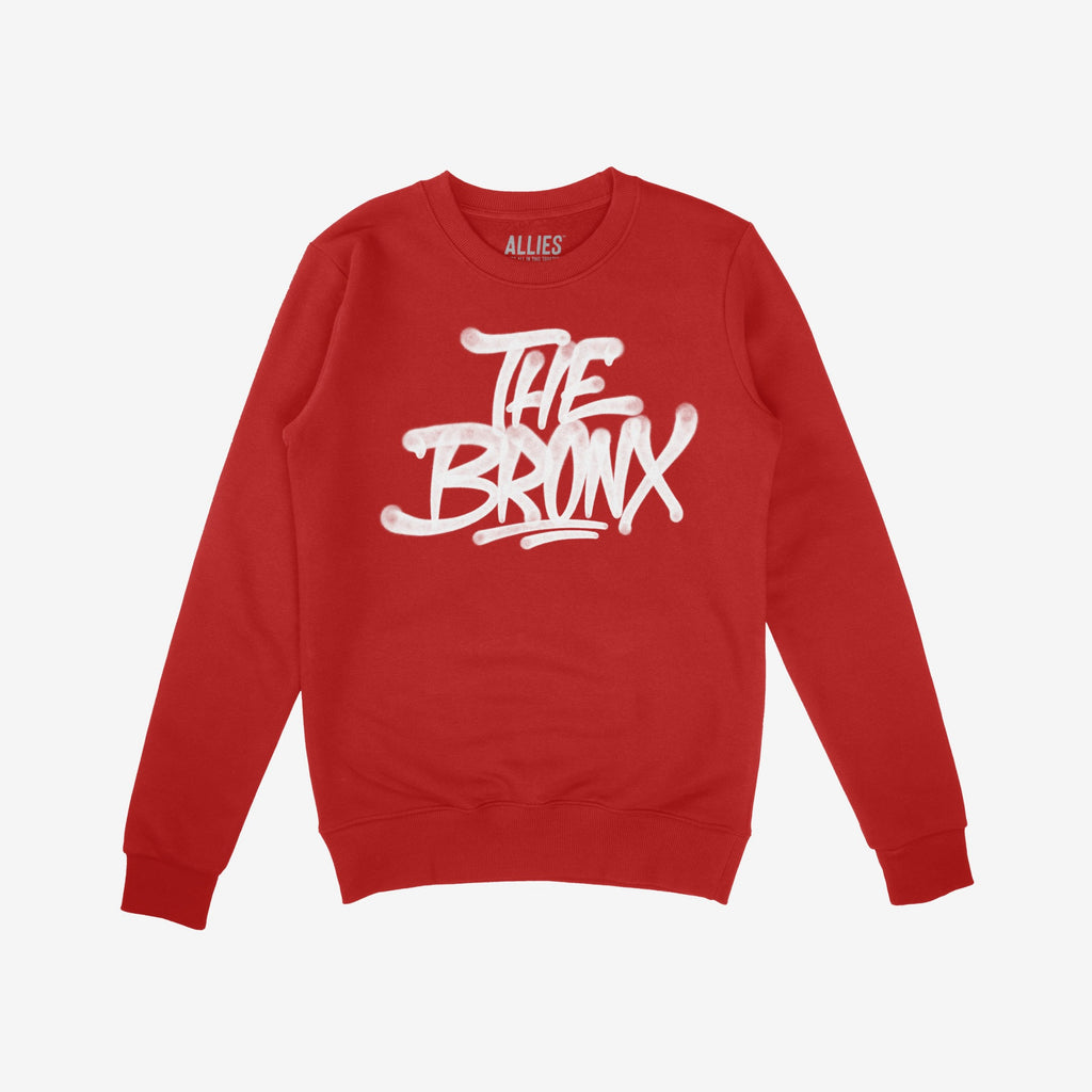 Bronx Handstyle Hoodie & Sweatshirt features a bold, graffiti-style THE BRONX print. This red crewneck showcases urban flair, embodying NYC spirit and resilience, ideal for showing borough pride.