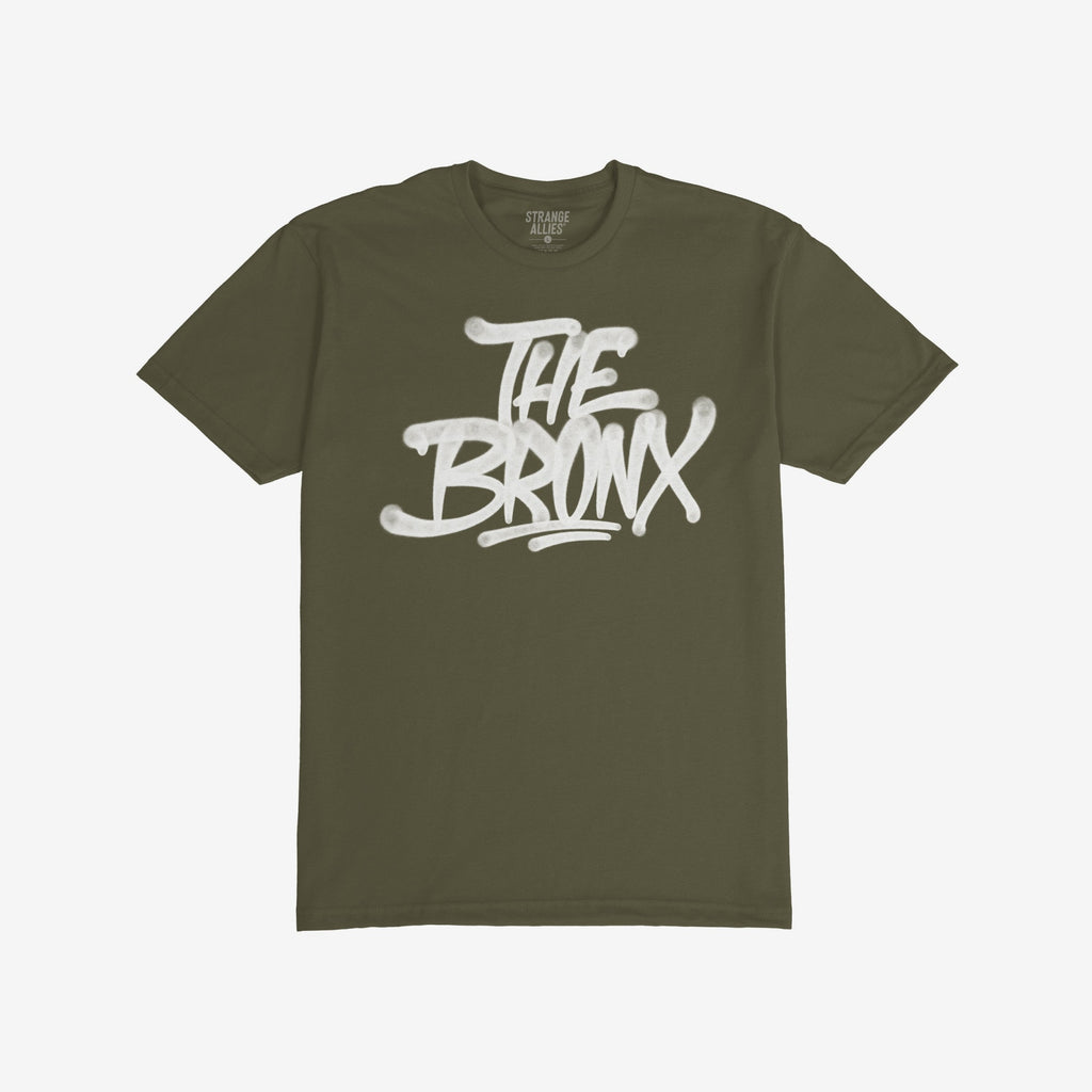 Bronx Handstyle T-shirt featuring bold white graffiti text THE BRONX on olive-green fabric, embodying raw urban pride and rebellion, perfectly aligned with the ethos of equality and anti-fascism.