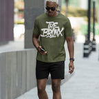 Young man in sunglasses wearing the Bronx Handstyle T-shirt, featuring bold graffiti-style THE BRONX text, embodying urban pride and rebellious spirit, perfect for expressing NYC roots.