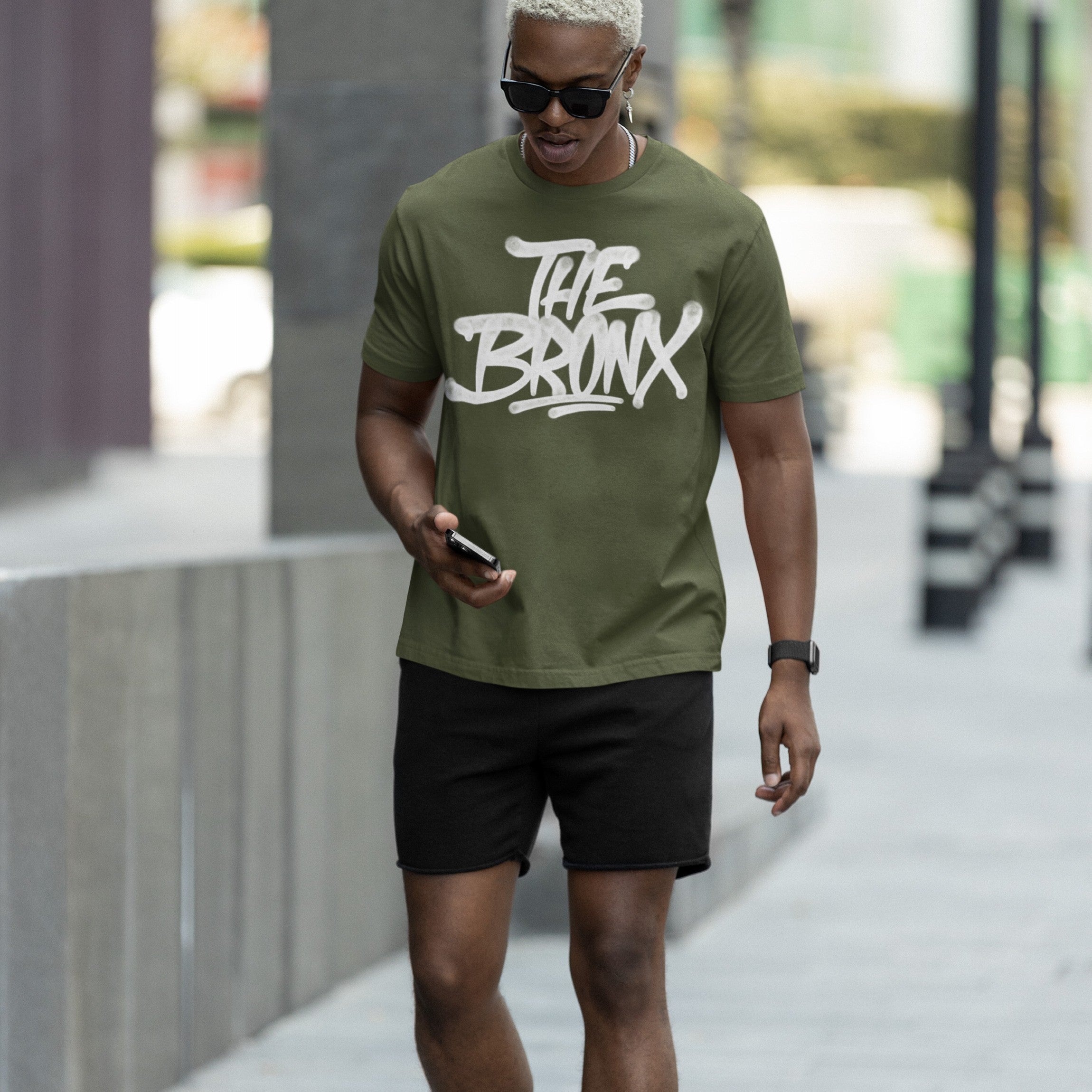 Young man in sunglasses wearing the Bronx Handstyle T-shirt, featuring bold graffiti-style THE BRONX text, embodying urban pride and rebellious spirit, perfect for expressing NYC roots.