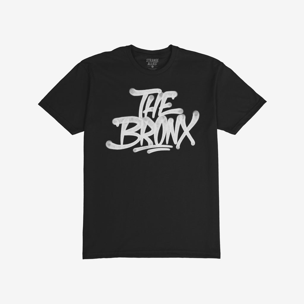Bronx Handstyle T-shirt featuring bold white graffiti-style THE BRONX text on black fabric, embodying raw borough pride. Perfect for sports fans and city enthusiasts, capturing the spirit of NYC.