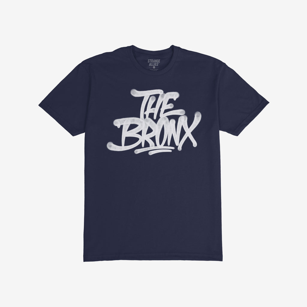 Bronx Handstyle T-shirt featuring a bold, white graffiti-style THE BRONX slogan on a dark navy-blue crew-neck, embodying borough pride and urban style. Ideal for NYC enthusiasts and locals.