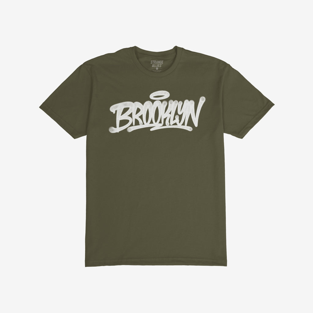 Army-green Brooklyn Handstyle T-shirt with bold white graffiti script, BROOKLYN, across the chest. Label reads “STRANGE ALLIES.” Ideal for city pride and everyday wear.