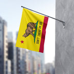 California Gadsden Flag mounted on a wall, featuring a brown bear on green grass with DON’T TREAD ON US text, embodies defiance and resistance against oppression. Perfect for rallies and statements.