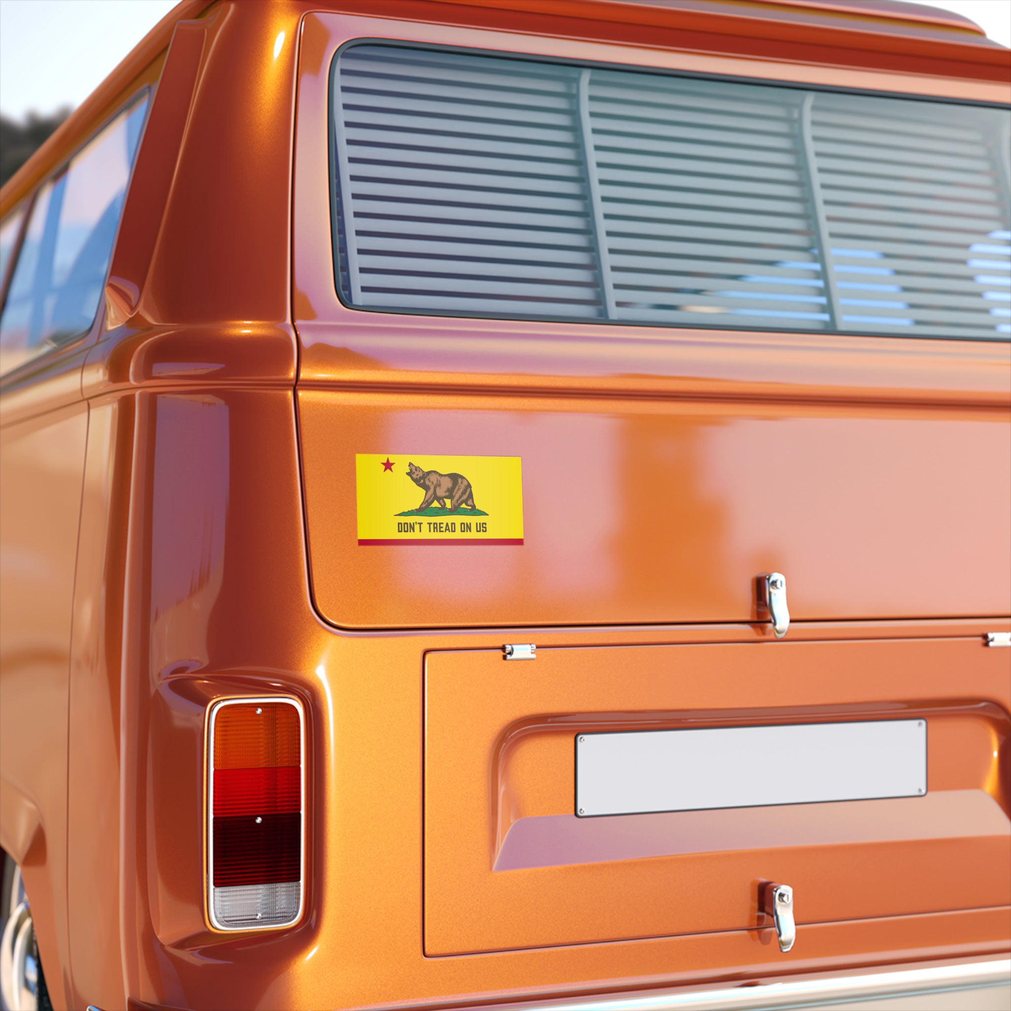 Rear end of an orange-metallic van showcasing the California Gadsden Flag Sticker & Magnet with a bear under a star and the slogan “DON’T TREAD ON US” on a yellow-and-red bumper sticker.