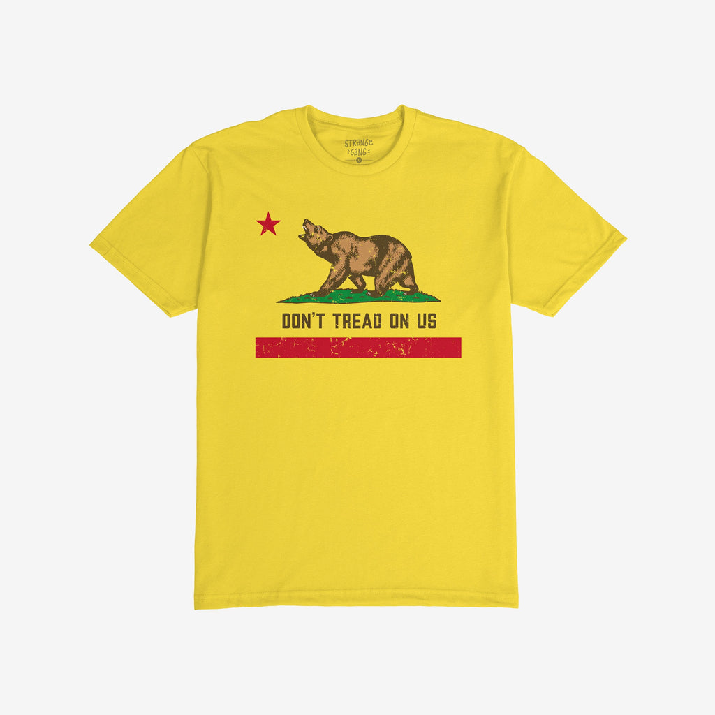 California Gadsden Flag Shirt with a bold bear graphic on grass, red star above, and DON'T TREAD ON US slogan. Features distressed red stripe, symbolizing resistance and state pride.