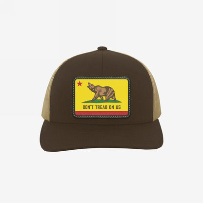 California Gadsden Flag Trucker Hat features a bold bear patch with Don't Tread On Us, symbolizing resistance and unity. Two-tone design with mesh back and adjustable fit for defiant comfort.